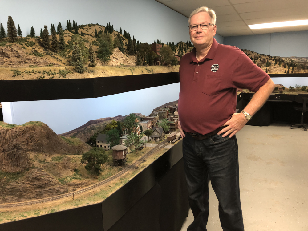man next to model train layout