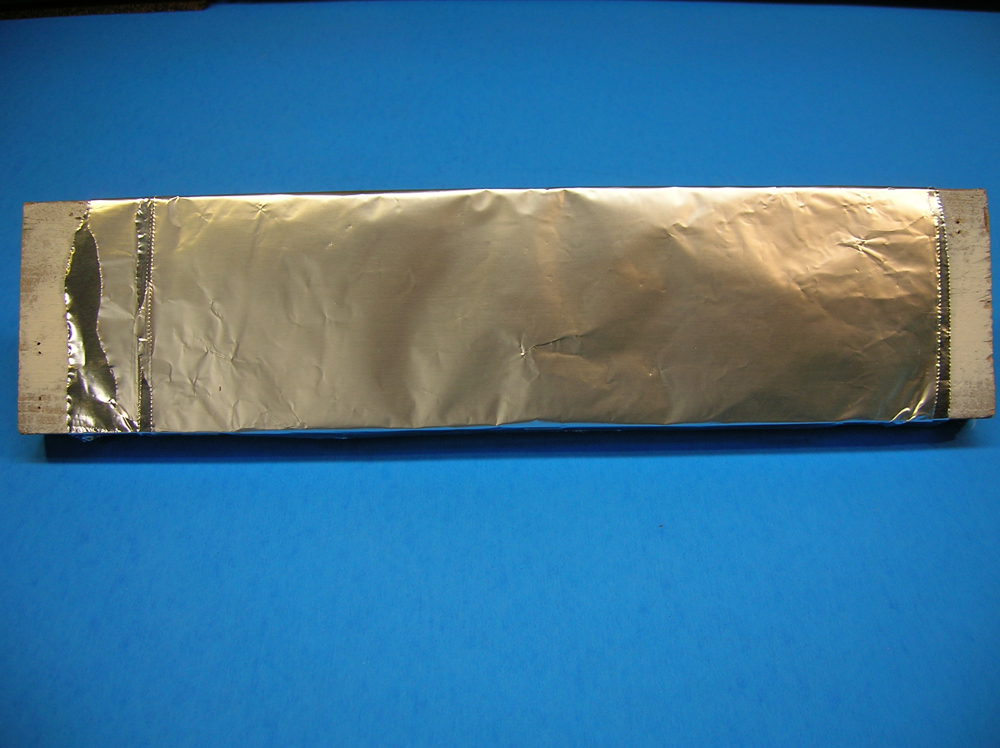 A piece of 1 x 4 wood covered with aluminum foil