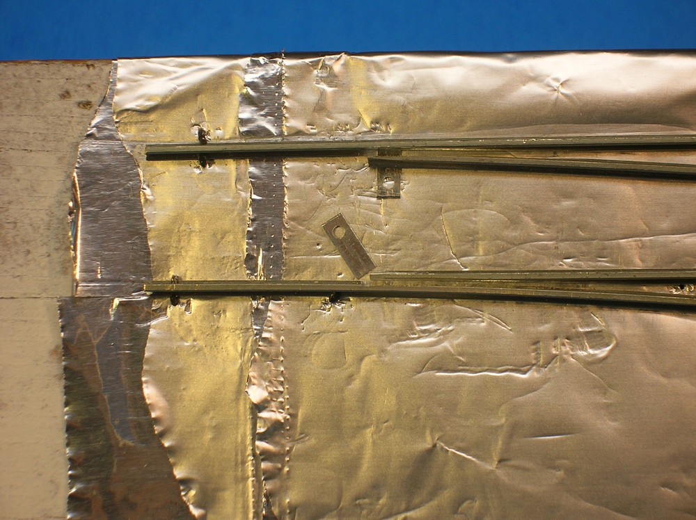 The completed point rail assembly of a turnout with metal tabs being attached