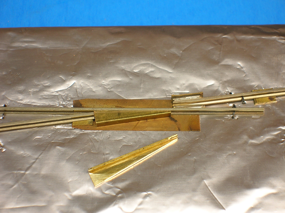 A model turnout frog area with pieces of brass channel stock