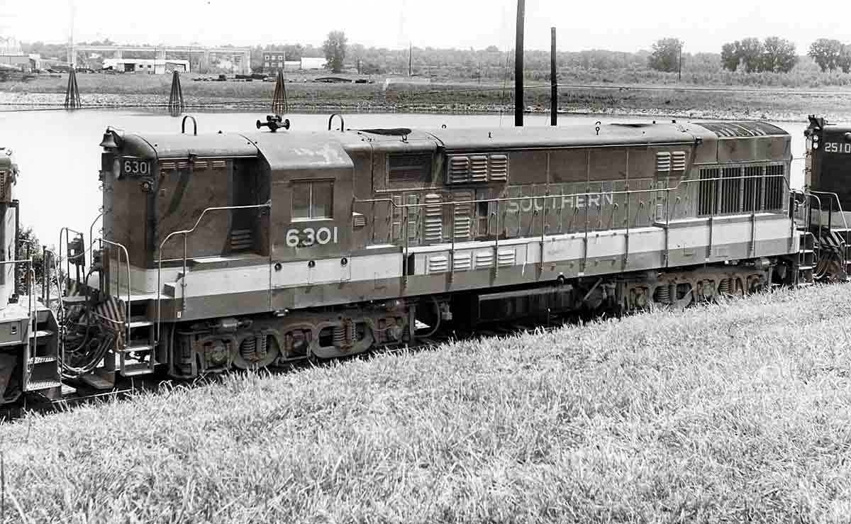 Six-axle Train Master diesel locomotive on freight train by pond