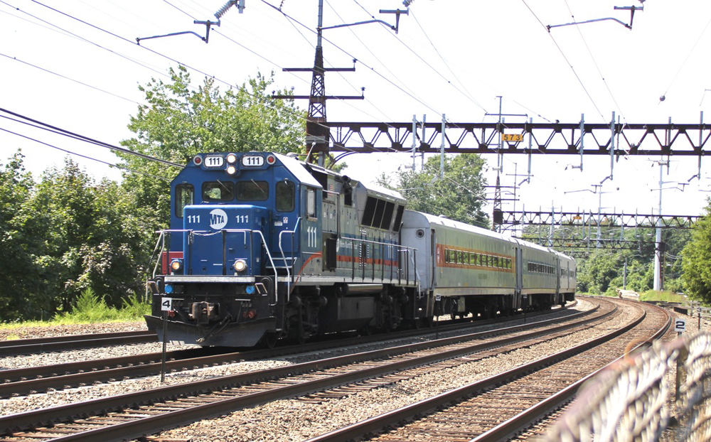 Commuter train with diesel locomotive on electrified line