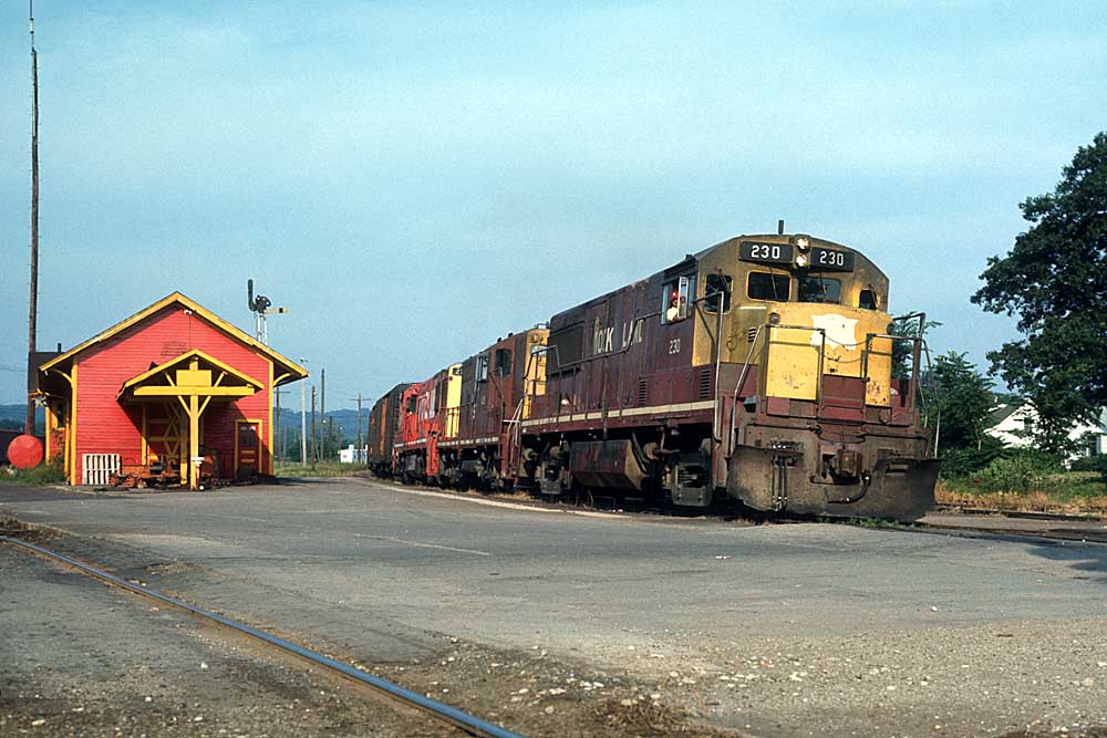 Diesel Rock Island locomotives on freight train by station