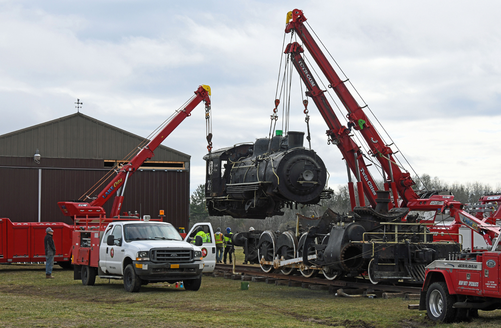 Part of locomotive suspended in air by cranes