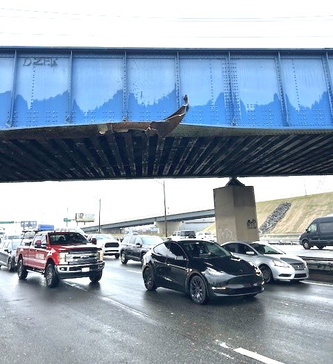 Blue steel railroad bridge across highway