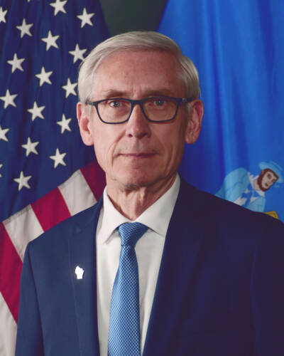 Wisconsin Governor Tony Evers official portrait who proposes passenger trains to NFL Draft.