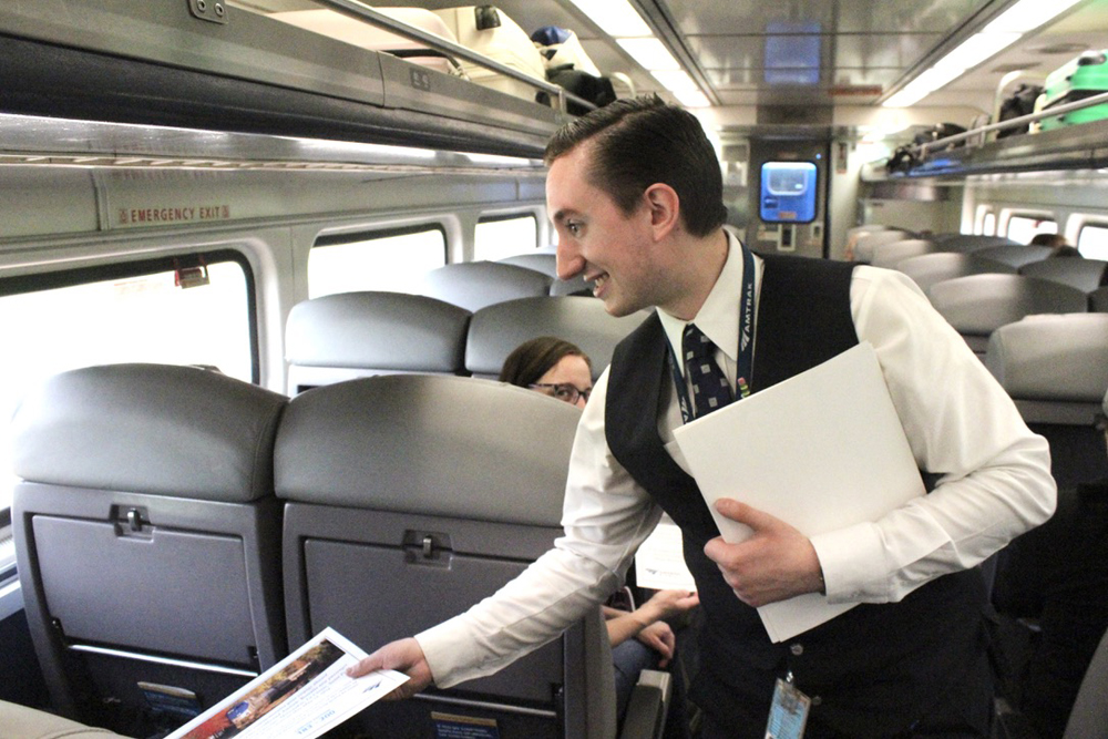 Amtrak employee hands out certificates to passengers