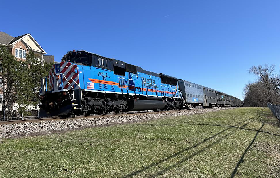 Blue six-axle diesel with commuter train