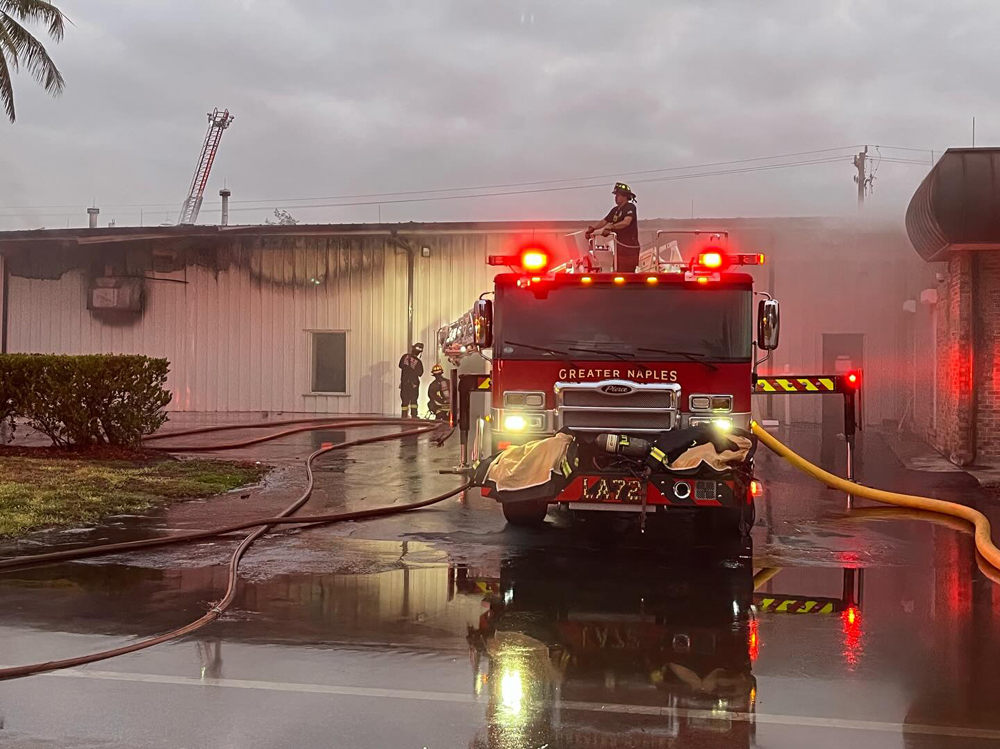 Fire truck outside building that shows burn damage