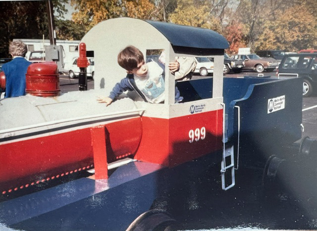 boy inside of red, white, and blue train