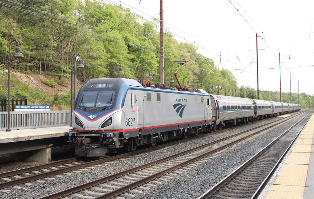 Passenger train with electric locomotive at station with high-level platform