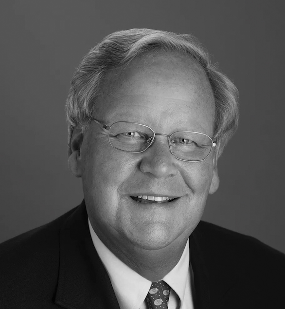 Black and white head shot of man in coat and tie