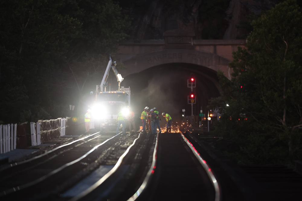 Hi-rail vehicle and workers on bridge at night