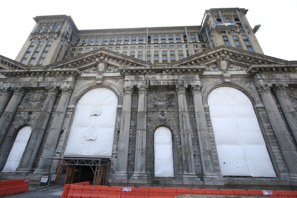 Front of station building with covered windows and some scaffolding.