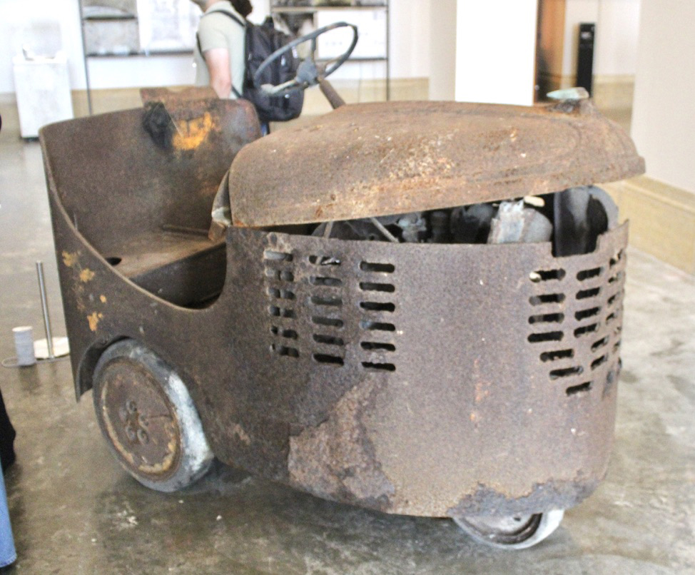 Small tractor used to move mail carts, covered in rust