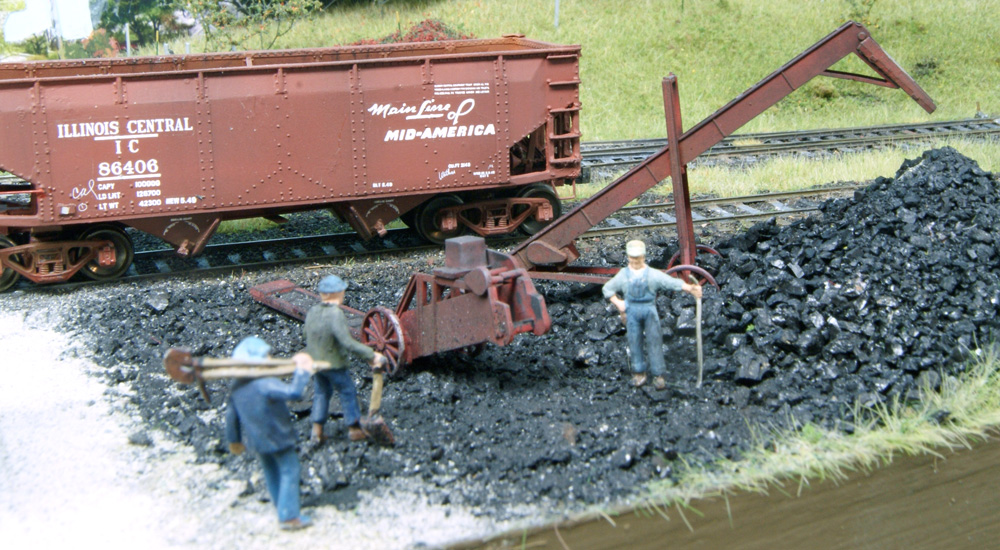 HO scale figures with shovels approach a conveyor in a coal yard