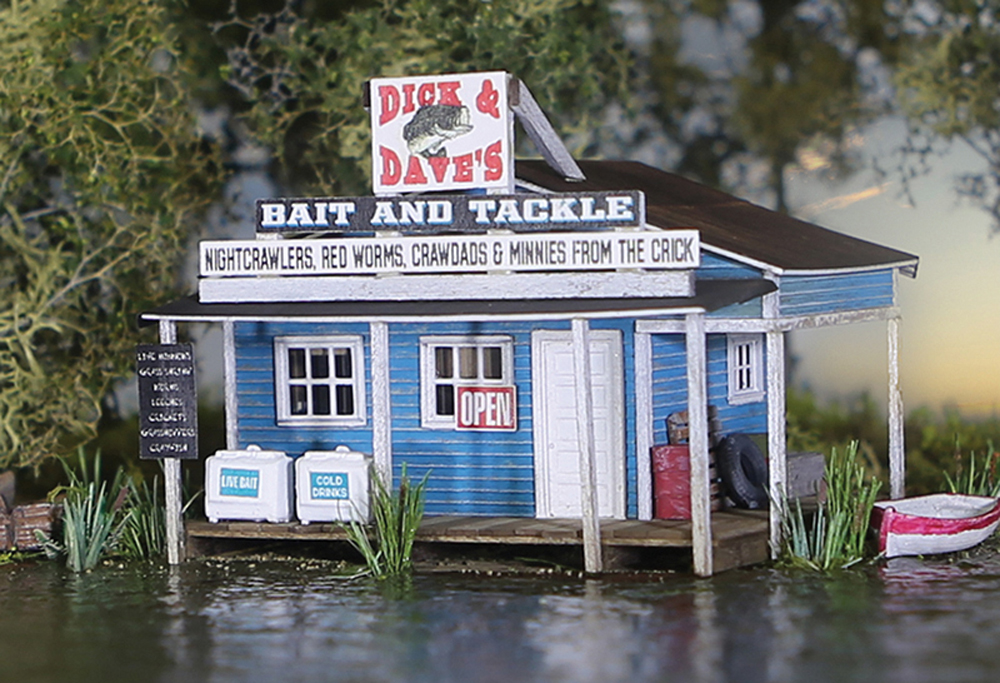 A blue model bait shop structure on a model railroad layout