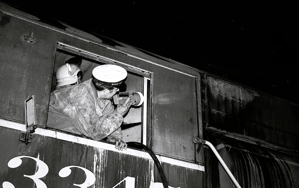 man looking at locomotive with flashlight