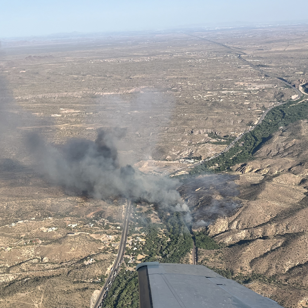 Aerial view of fire in desert area near railroad tracks