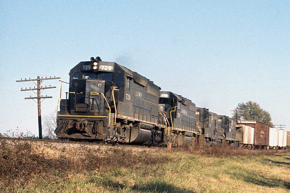 Three black diesel Atlanta & West Point locomotives with freight train on elevated trackage