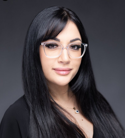 Head shot of woman with long dark hair and glasses