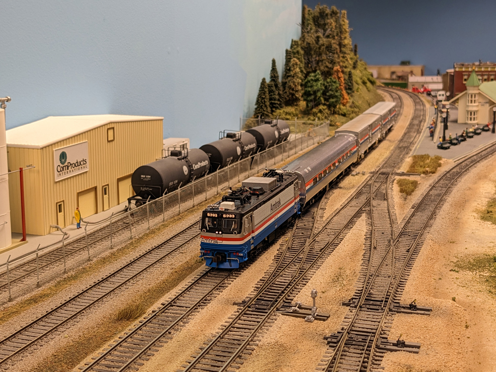 A model amtrak train in a staging and interchange yard on a model railroad layout