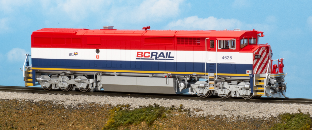 Color photo of red, white, and blue HO diesel on scenic base.