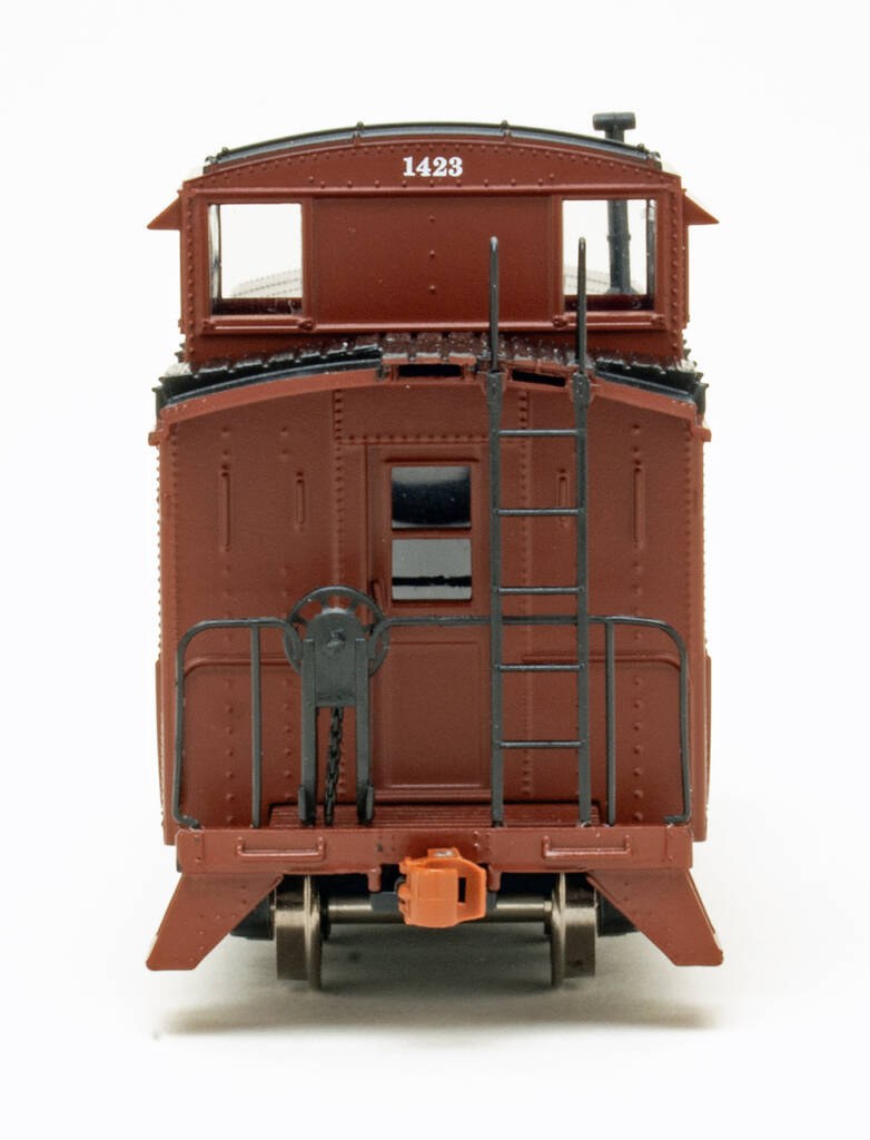 End view of HO scale caboose painted brown and black on white background.