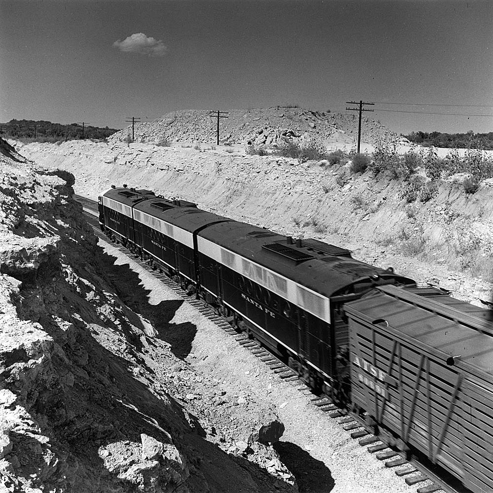 Streamlined diesel locomotives with freight train in cut