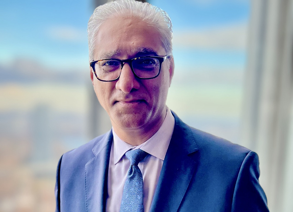 Man in blue suit with window as backdrop