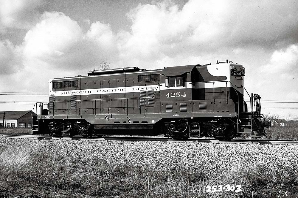Striped mid-cab diesel locomotive under cloudy 