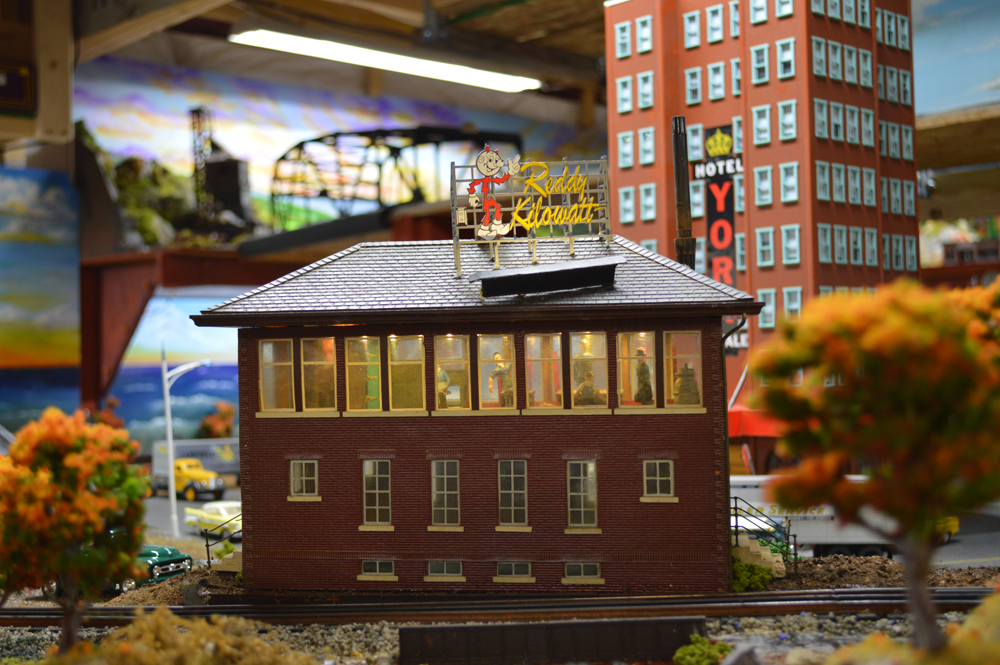 preserving the history of model railroading: A building on a model railroad layout with a sign on its roof that reads "Reddy Kilowatt"