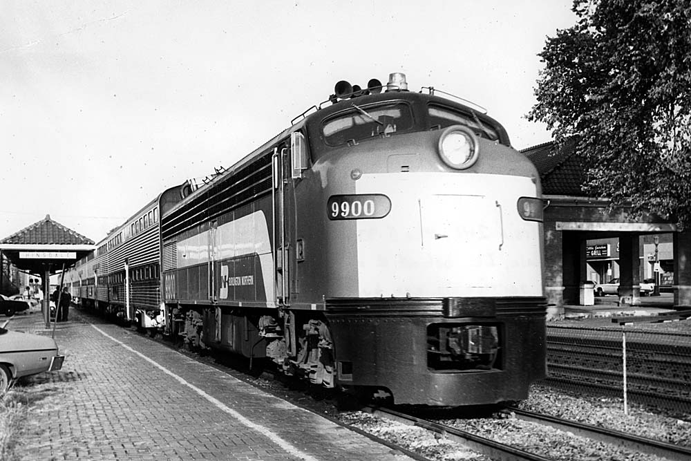 Streamlined diesel locomotive with passenger train at brick station