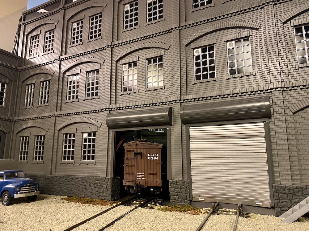 A dark-grey three-story building serves as a partition.