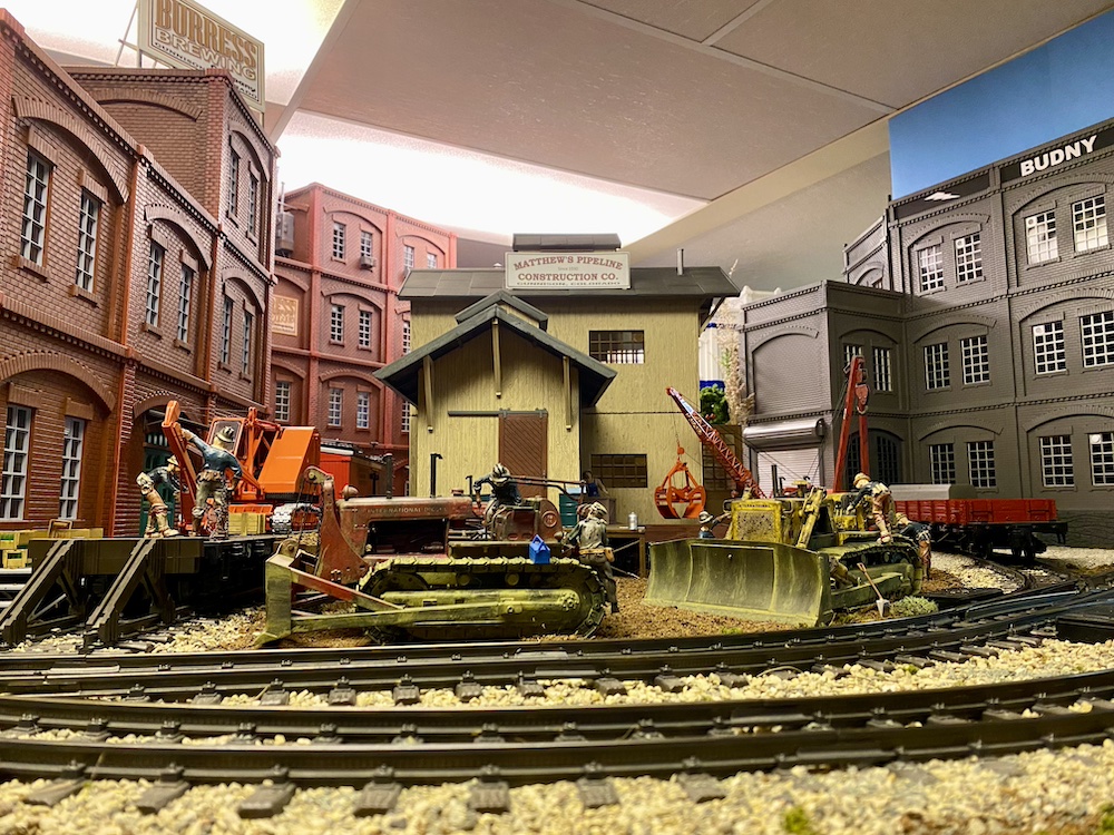 Scratch-built buildings in front of a curving main line