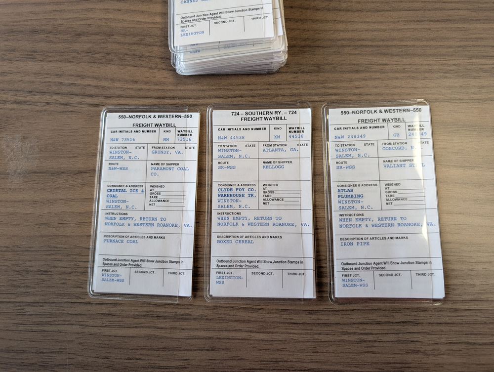 Three model railroad car cards in a row.