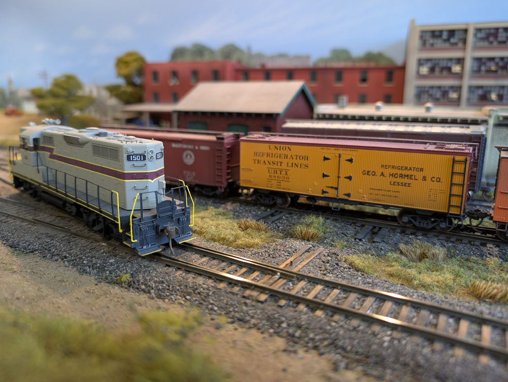 An HO scale GP7 running around a boxcar and reefer