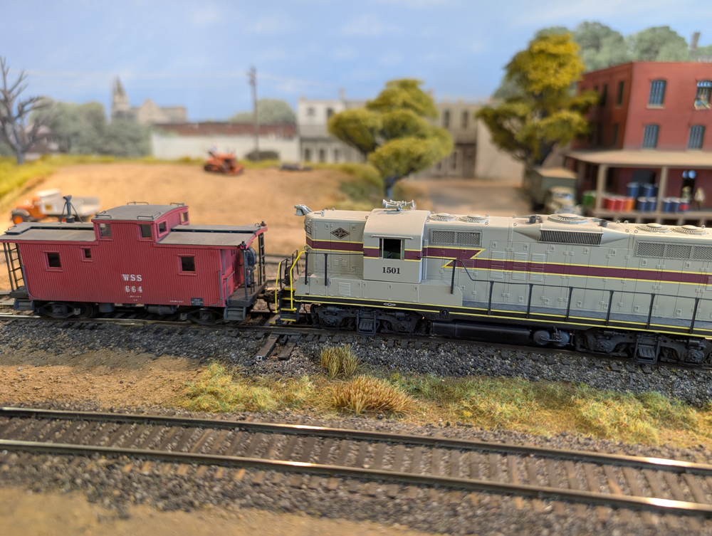 An HO scale GP7 shoving a caboose