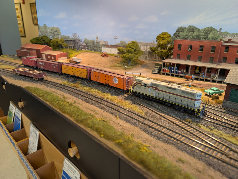 An HO scale GP7 with two reefers, a boxcar, and a caboose behind it