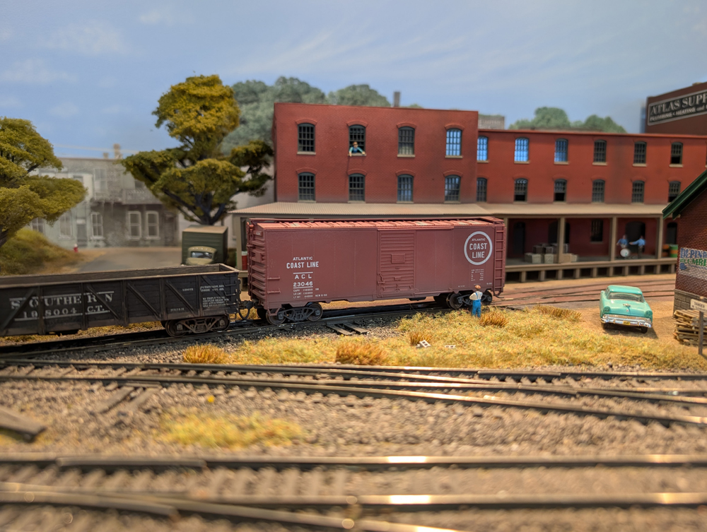 An HO scale gondola and boxcar at an industry