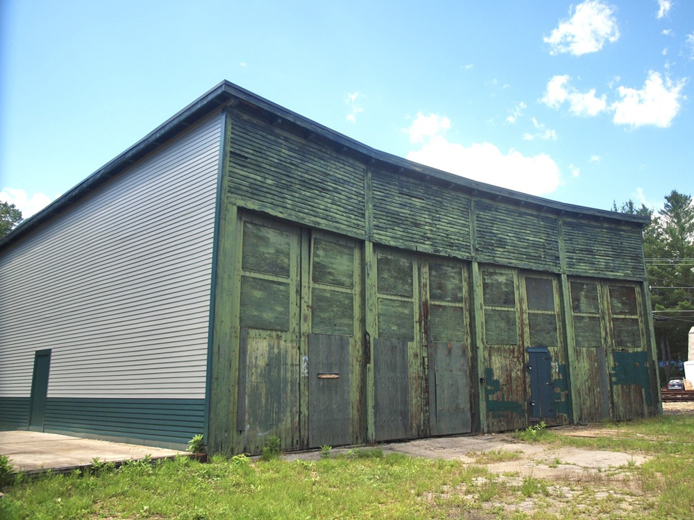 Wooden four-stall roundhouse with weathered green doors