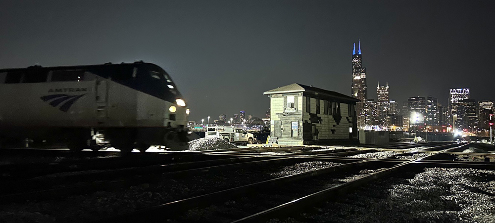 Passenger train passes with tower in background