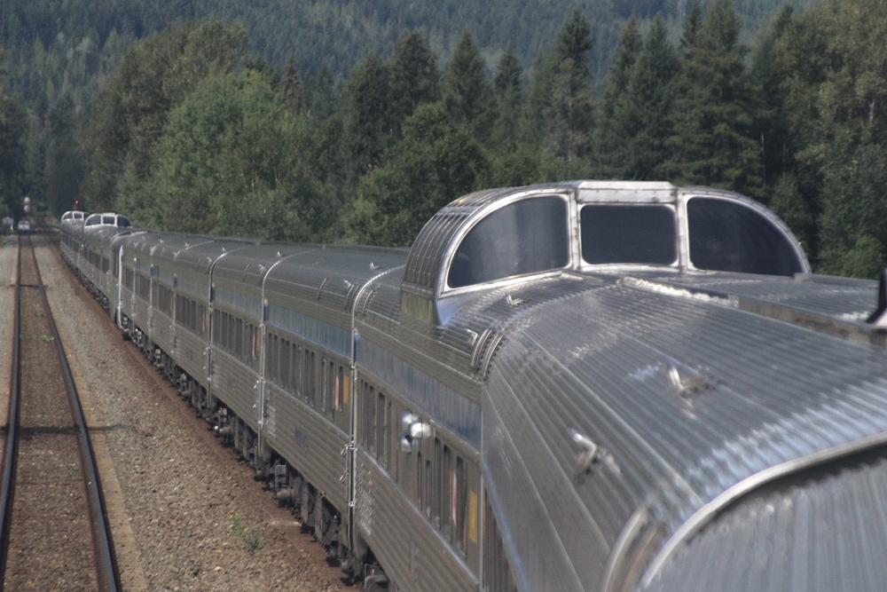 View of long passenger train from dome car