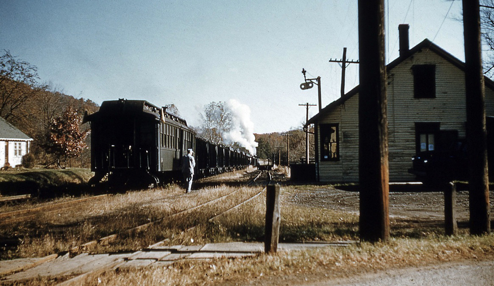 View of rear of train at smalll wooden station