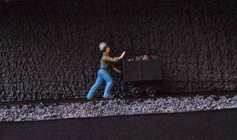 model figure pushing cart on train layout