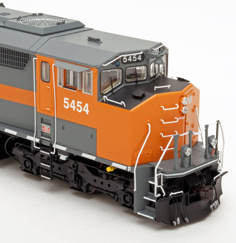 Color photo showing front end of HO scale diesel painted gray and orange on white background.