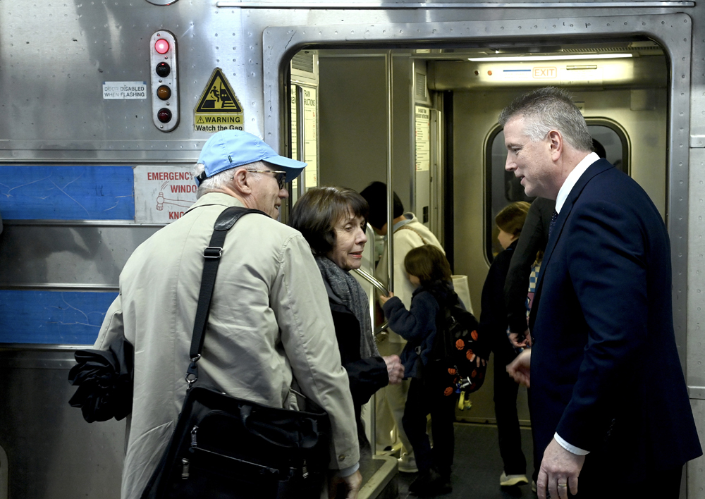 Man in suit talking to people boarding