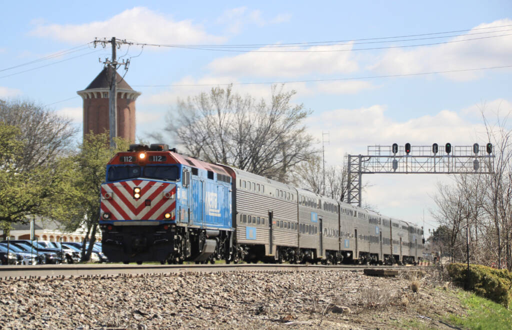 Commuter train passing under signal bridge