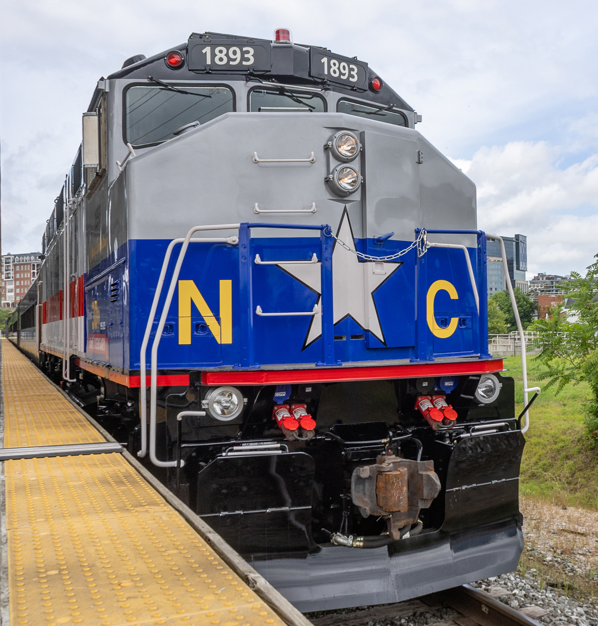 Nose view of blue and silver locomotive with red trip and yellow lettering