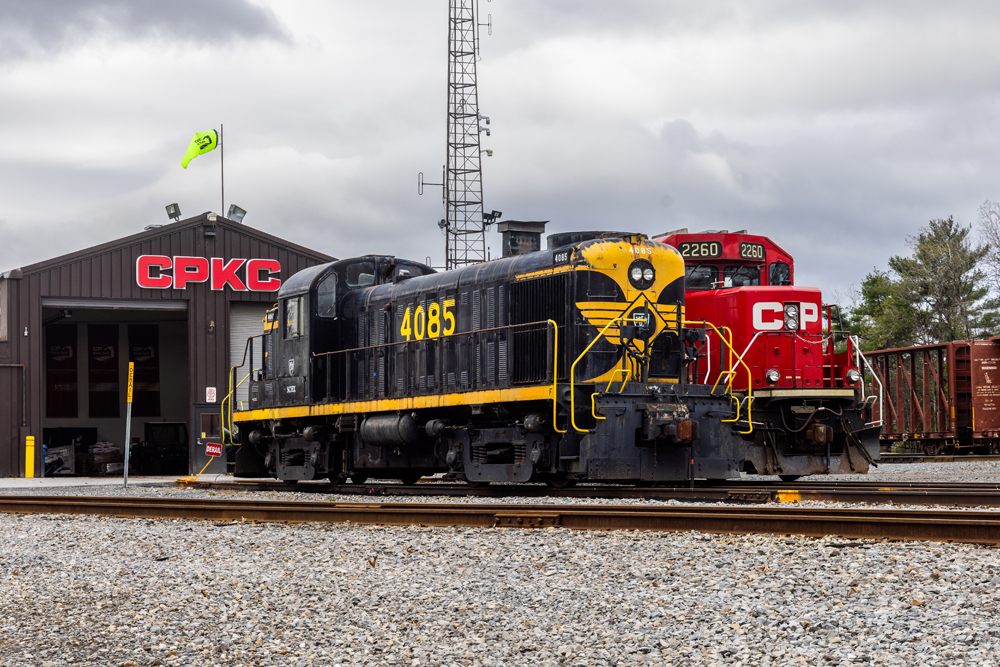 Vintage black and yellow diesel next to current CPKC unit